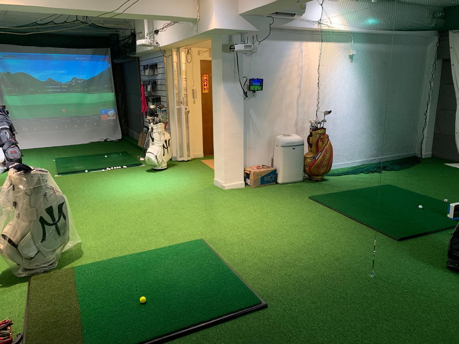 Multiple practice mats and hitting bays inside the Golf Partners studio